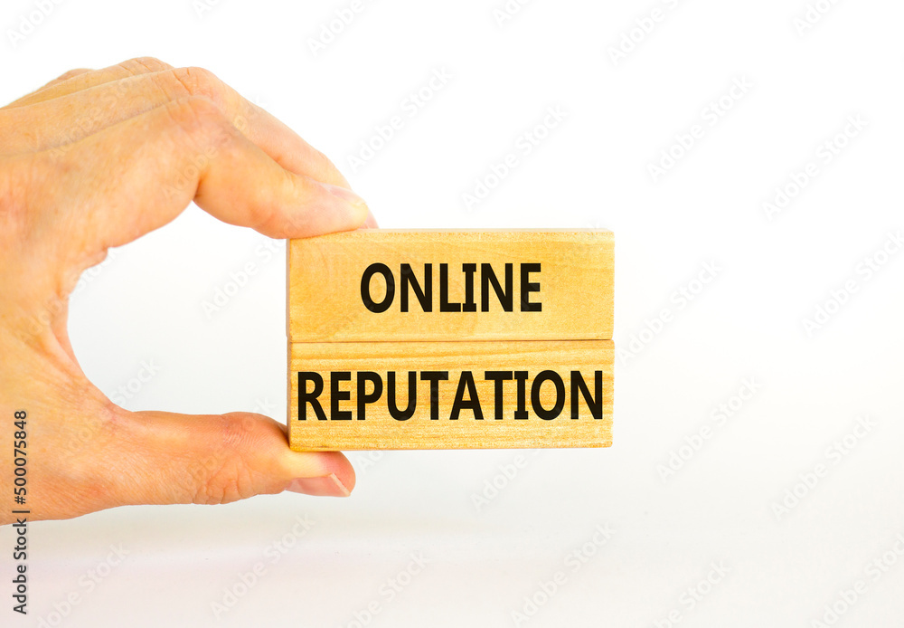 Online reputation symbol. Wooden blocks with concept words Online reputation on beautiful white background. Businessman hand. Business online reputation concept. Copy space. Online reputation symbol. Wooden blocks with concept words Online reputation on beautiful white background. Businessman hand. Business online reputation concept. Copy space.
