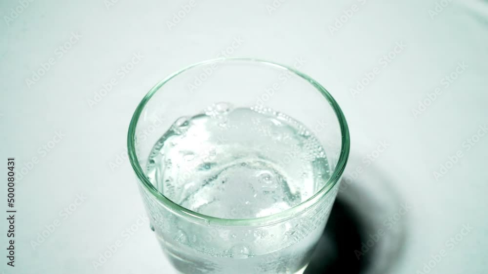 Antacid tablet dropped into water in white background Antacid tablet dropped into water in white background