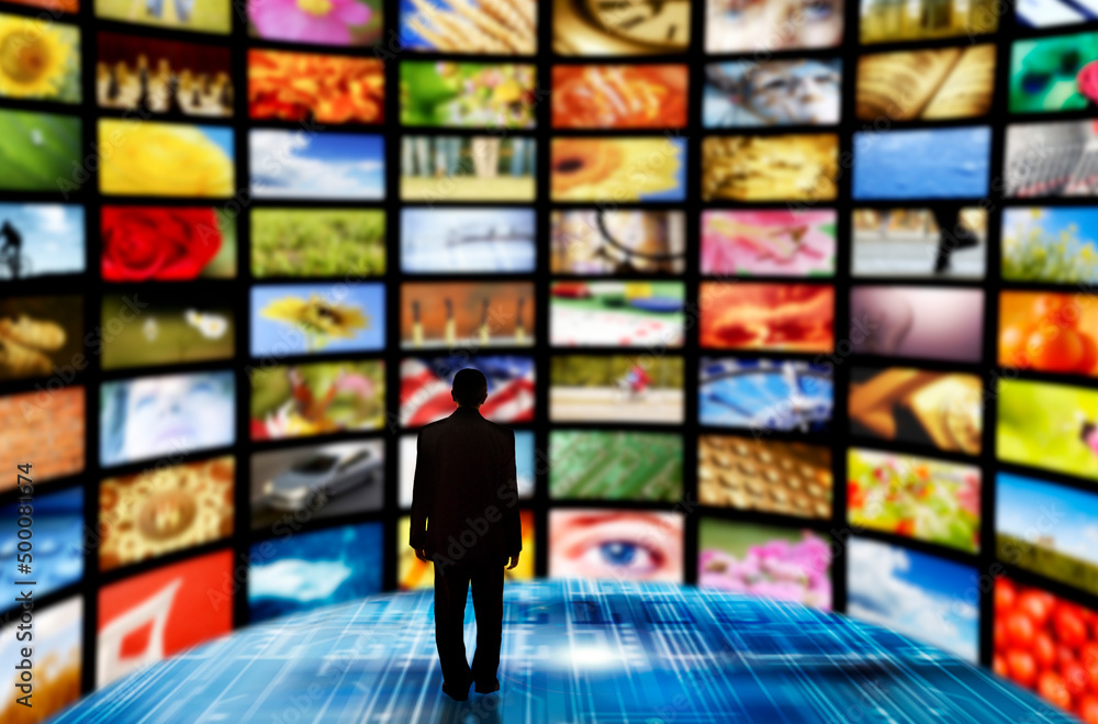 man inside a room with many screens with images man inside a room with many screens with images