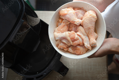 several pieces of chicken drumsticks in a white cup It's about to be fried in an oil-free fryer.