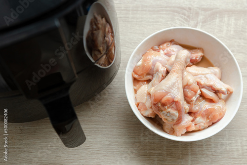 several pieces of chicken drumsticks in a white cup It's about to be fried in an oil-free fryer.