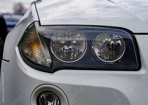 Headlight of new modern white car close up