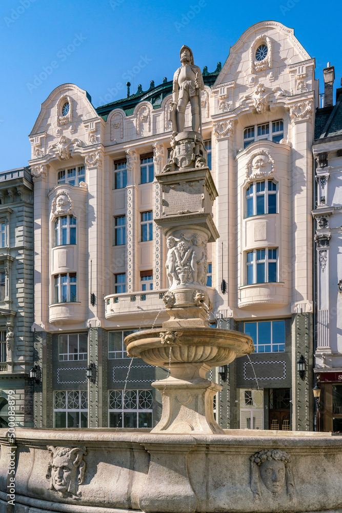 Famous Roland fountain on main square of Bratislava with restored historical buildings in background