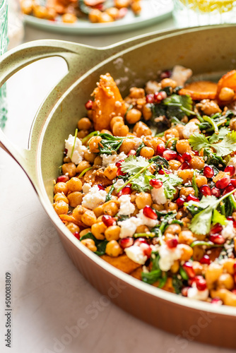 Chickpea salad with roasted yams, spinach, pomegranate, feta cheese, coriander, sesame seeds. 