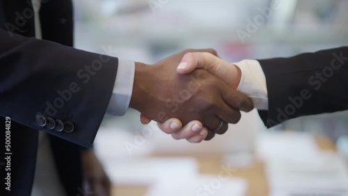 Closeup dolly shot of two businesspeople shaking hands in the office for a successful agreement.