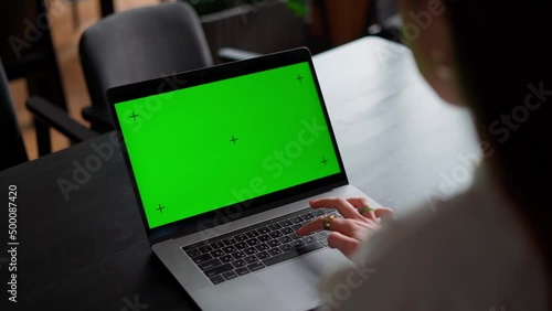girl typing on laptop with green screen
