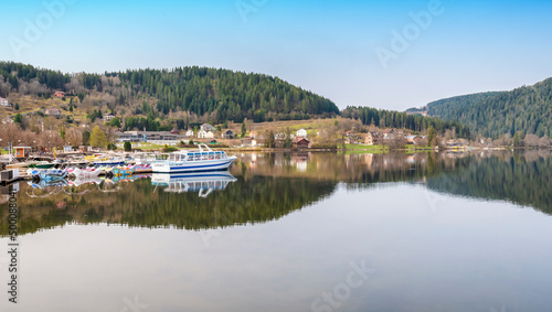 Bateaux pour visiter et découvrir le lac de Gérardmer dans les Vosges. Paysage de montagne et de conifères.