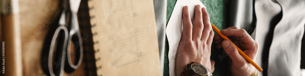 Fototapeta premium White craftsman working with leather at wooden table in workshop
