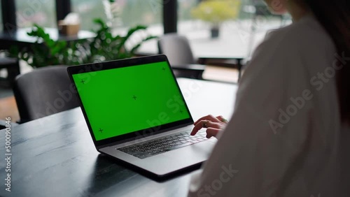 girl typing on laptop with green screen