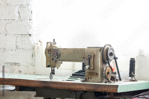 Old sewing machine on a table with a window in the background