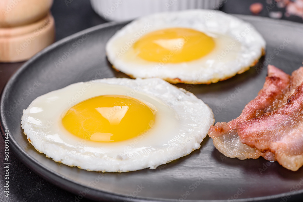 English breakfast with fried eggs, bacon, beans, tomatoes, spices and herbs English breakfast with fried eggs, bacon, beans, tomatoes, spices and herbs