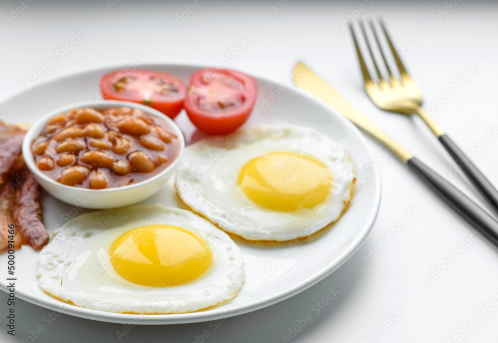 English breakfast with fried eggs, bacon, beans, tomatoes, spices and herbs English breakfast with fried eggs, bacon, beans, tomatoes, spices and herbs