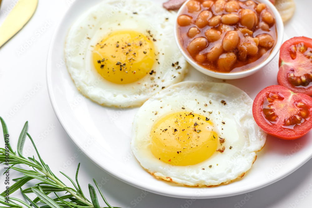 English breakfast with fried eggs, bacon, beans, tomatoes, spices and herbs English breakfast with fried eggs, bacon, beans, tomatoes, spices and herbs