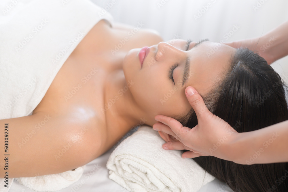 Young asian beautiful woman relaxing and enjoying head massage, spa and beauty treatment concept Young asian beautiful woman relaxing and enjoying head massage, spa and beauty treatment concept