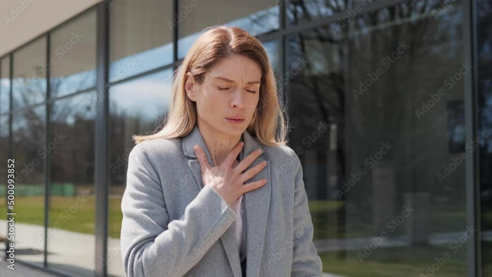 Adult Sick Business Woman wearing formal suit Coughing while Standing Outdoor. Close up portrait of unwell beautiful Caucasian woman coughs having pain in chest. Infection and virus. Health concept. Adult Sick Business Woman wearing formal suit Coughing while Standing Outdoor. Close up portrait of unwell beautiful Caucasian woman coughs having pain in chest. Infection and virus. Health concept.