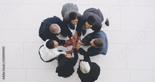 Teamwork wins every time. 4k footage of a group of businesspeople joining their hands together in a huddle. photo
