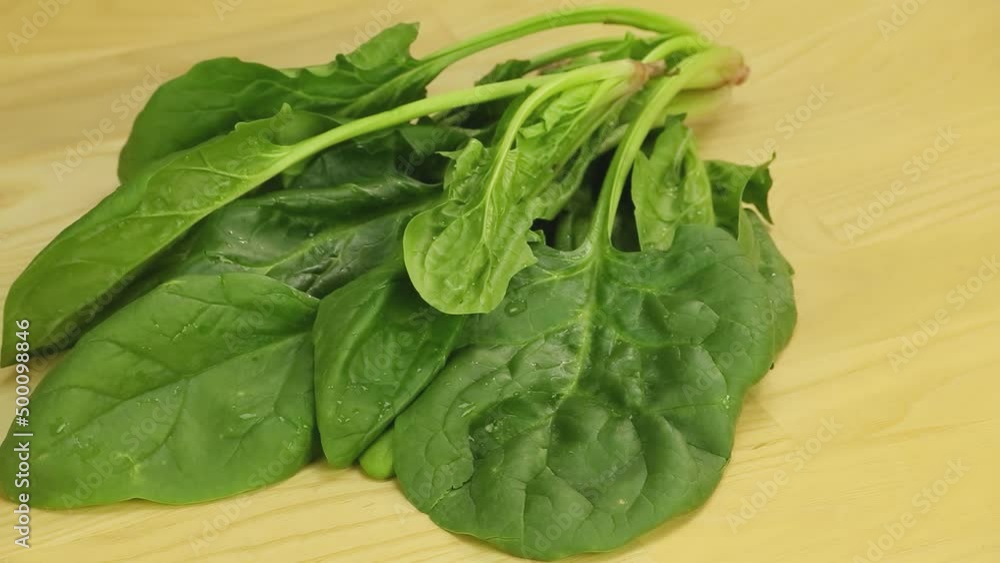 Spinach leaves spin on the background of wooden boards Spinach leaves spin on the background of wooden boards