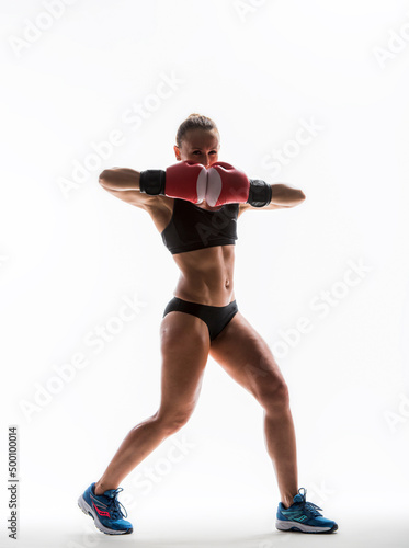 Athletic young woman with boxing gloves at workout isolated on white © serhii