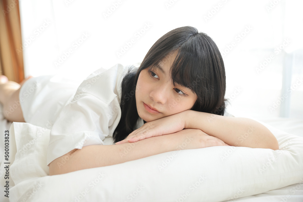 Beautiful young woman waking up in the morning at white bedroom Beautiful young woman waking up in the morning at white bedroom