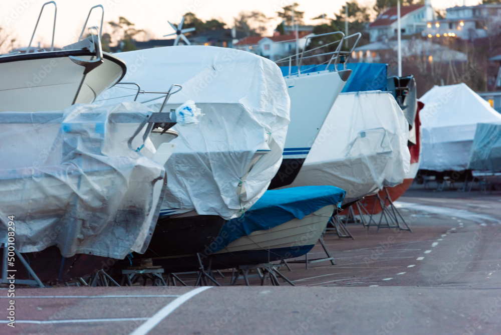 Boats laid up for the winter on a parking lot.
