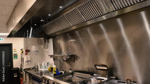 Professional chef in the kitchen of a restaurant. A male chef in a black uniform is working in the kitchen. Slow motion 4K