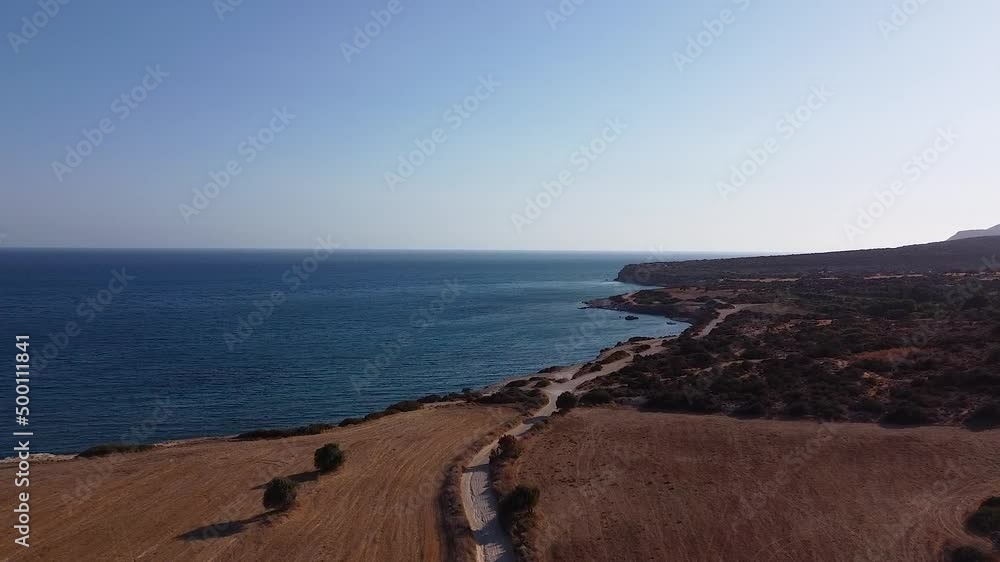 Beautiful aerial views of a road path next to the sea during a sunny summer day in Greece. Beautiful aerial views of a road path next to the sea during a sunny summer day in Greece.