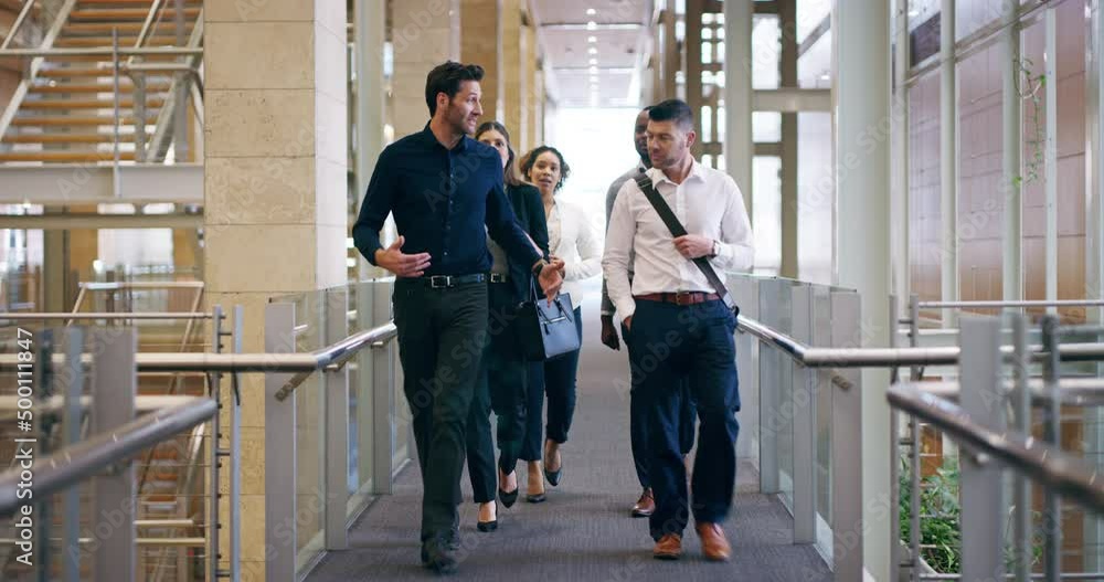 Walking in, ready for business. 4k video footage of a group of businesspeople walking through their office building.