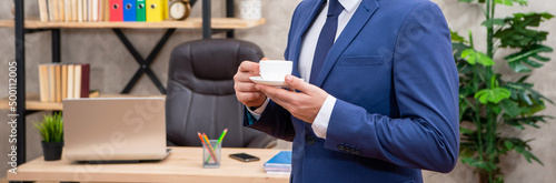 cropped entrepreneur in jacket having coffee break at office, businessperson