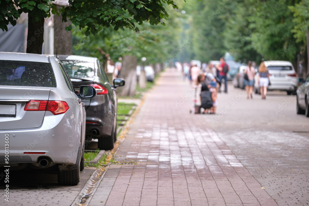Fototapeta premium City traffic with cars parked in line on street side