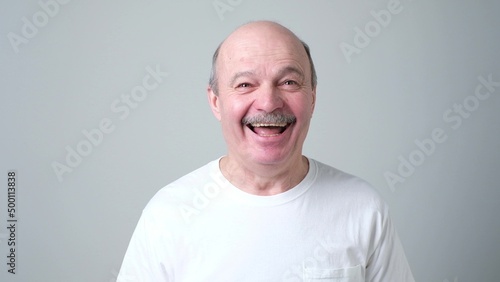 Handsome senior man in white t-shirt laughing © Viktor Koldunov