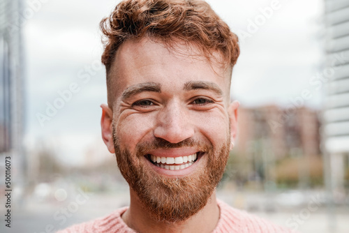 Happy ginger hair man smiling on camera outdoor - Redhead authentic people concept