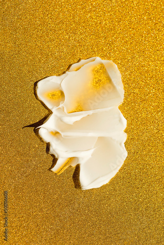 A swatch of cream or face mask. The appearance of the texture of the cream on shimmer golden paper. Skincare products , natural cosmetic. Beauty concept for face and body care