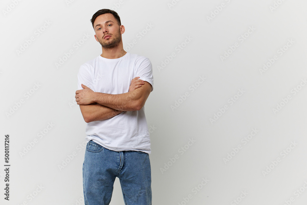 Serious self confident tanned handsome man in basic t-shirt folded arms look at camera posing isolated on over white studio background. Copy space Banner Mockup. People emotions Lifestyle concept Serious self confident tanned handsome man in basic t-shirt folded arms look at camera posing isolated on over white studio background. Copy space Banner Mockup. People emotions Lifestyle concept