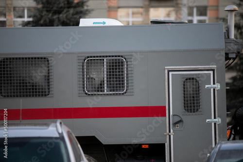 russian national guard officer inside of riot police truck window behind metal grate photo