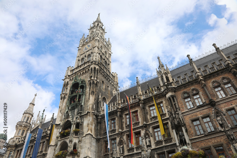 High clock tower of the new town hall of Munich in Germany and the flags
