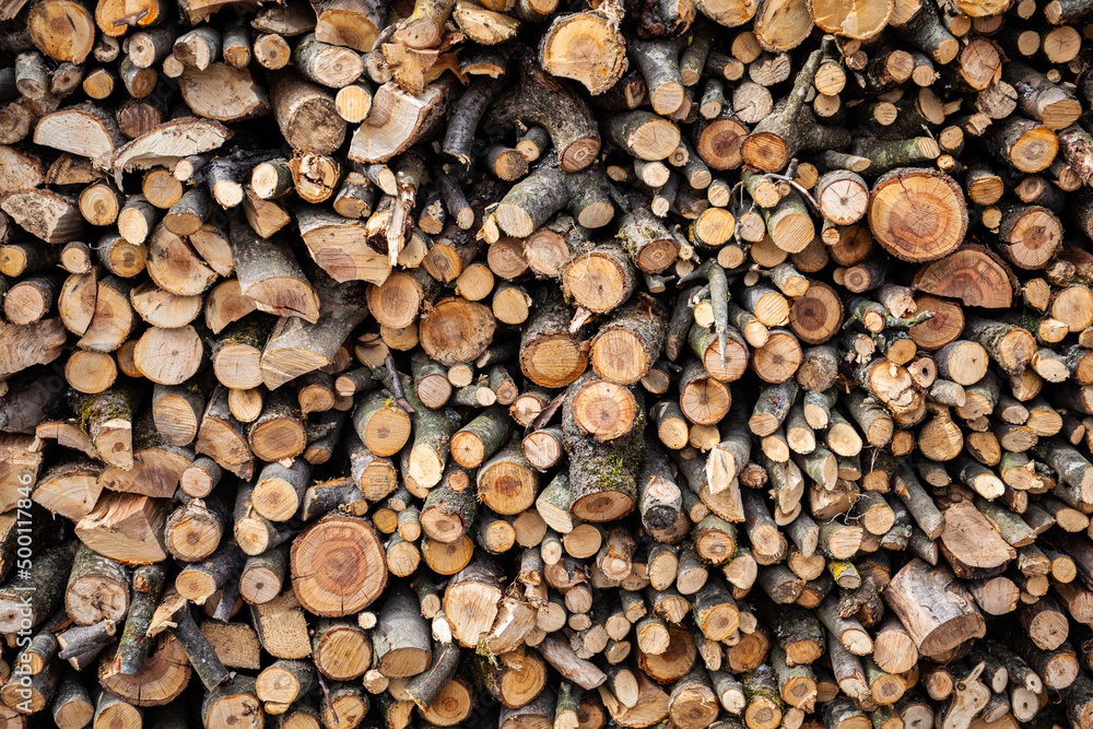 Stack of firewood - background for design. Ecological fuel, renewable energy source.