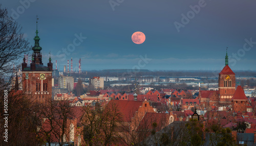 A full moon rising over the city of Gdansk at dusk. Poland photo