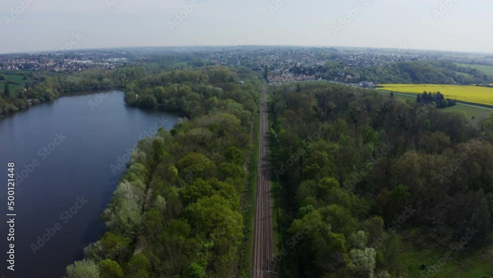 Aerial view of a train track in the countryside. Railway from a bird's eye view passing through the green forest. Filmed in 4k, drone video. Railway and small country town. Aerial view of a train track in the countryside. Railway from a bird's eye view passing through the green forest. Filmed in 4k, drone video. Railway and small country town.