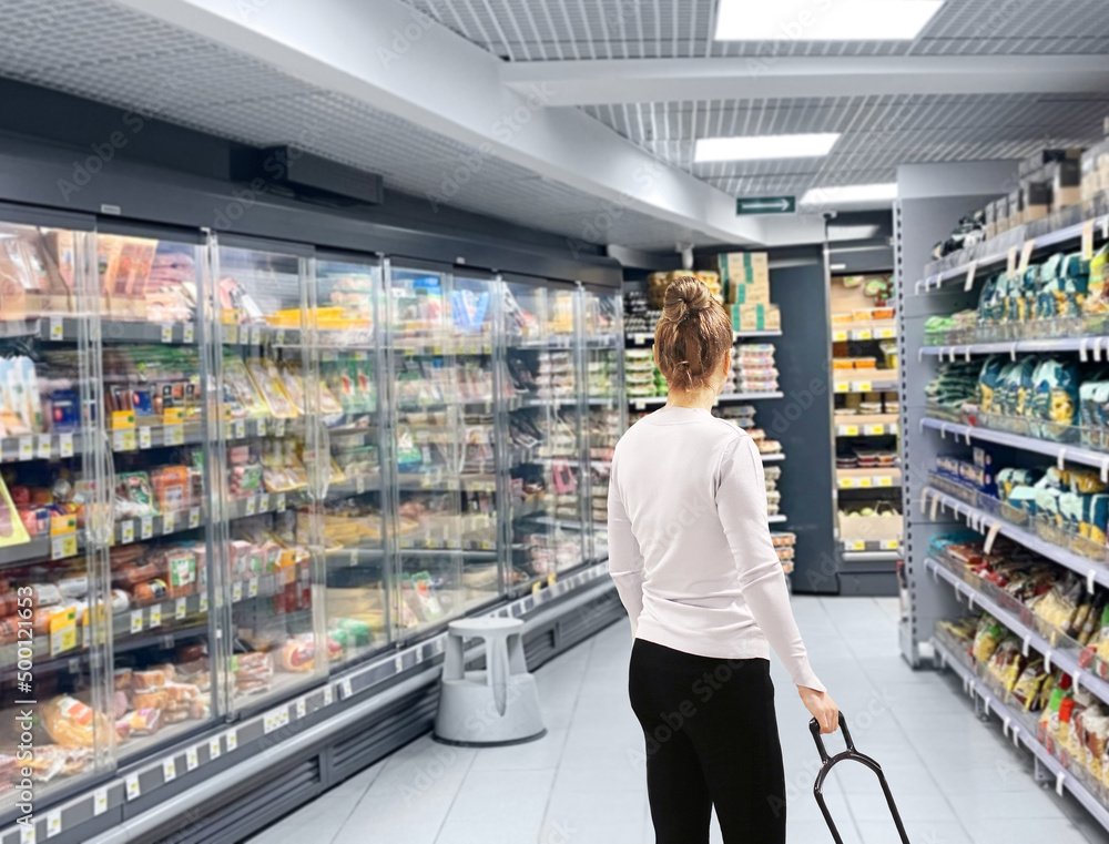 Woman choosing frozen food from a supermarket freezer	