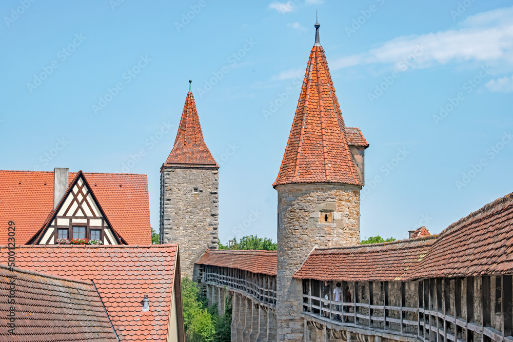 Tourists walk along a walkway within the city wall of Rothenberg, Germany, that protected the town in ancient times. Tourists walk along a walkway within the city wall of Rothenberg, Germany, that protected the town in ancient times.