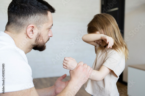 The concept of violence and abuse in the family. Father punishing his child. photo