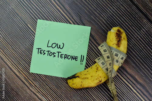 Low Testoterone write on sticky notes and Banana isolated on Wooden Table.