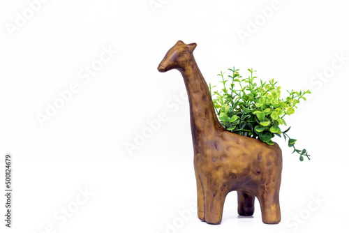 Photography Wooden figurine of a giraffe with green plants on the back.