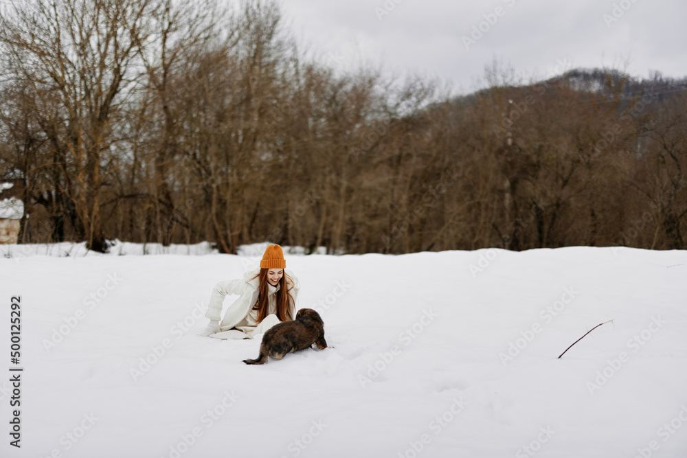 young woman outdoors in a field in winter walking with a dog winter holidays