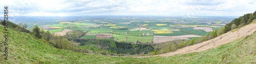 Large panoramic view taken from the top of The Wrekin hill 407 meters above sea level in Shropshire, England, UK. Green, brown and yellow fields fill the countryside with Welsh hills in the background photo