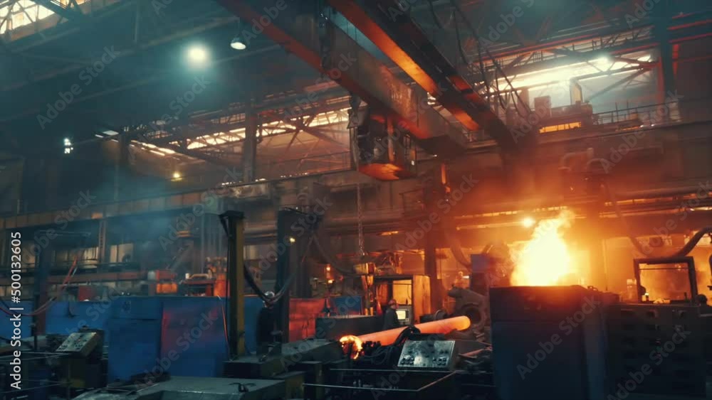 Metal casting in metallurgical plant or factory. Process of melting and forming production of iron pipes in industrial machines in workshop. Metal casting in metallurgical plant or factory. Process of melting and forming production of iron pipes in industrial machines in workshop.