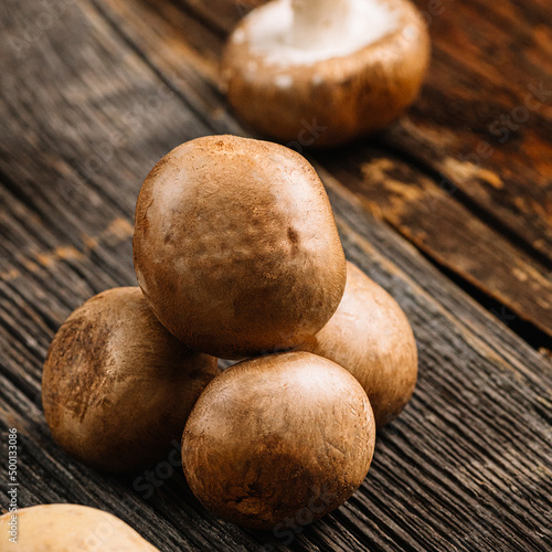 Brown mushrooms, champignon on wooden background, selective focus