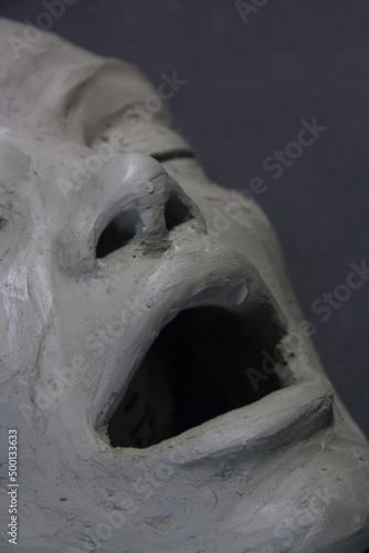 Portrait of the girl with open mouth. Expressive sculpture, female face. Process of clay modeling. Figurative art, contemporary, handmade artwork.