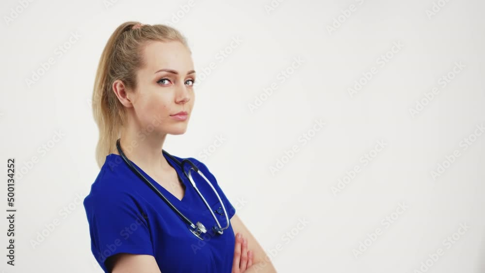 blonde beautiful nurse stands facing the camera with her hands folded, isolated white background copyspace . High quality 4k footage blonde beautiful nurse stands facing the camera with her hands folded, isolated white background copyspace . High quality 4k footage