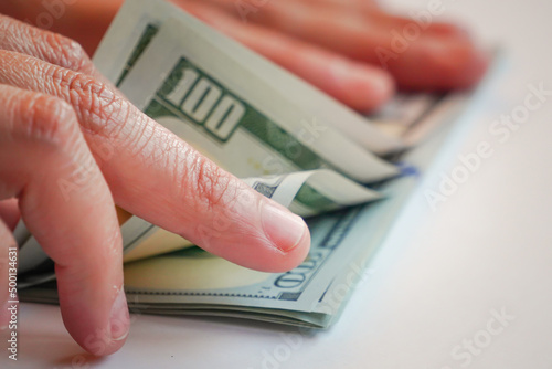 hand counting U.S. dollars, U.S. bills, the world currency is the U.S. dollar.